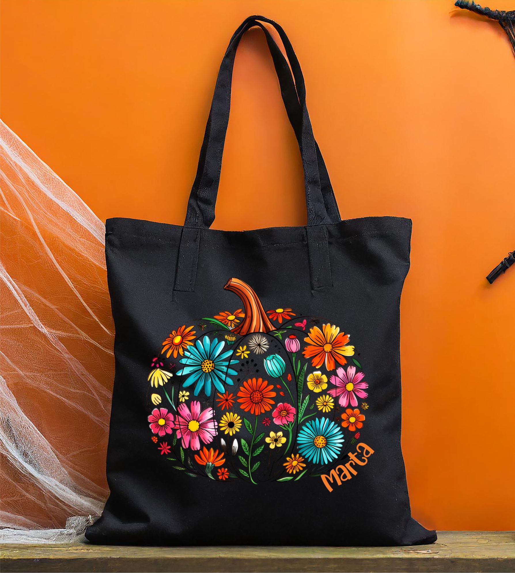 Bolsa de tela negra con calabaza de flores
