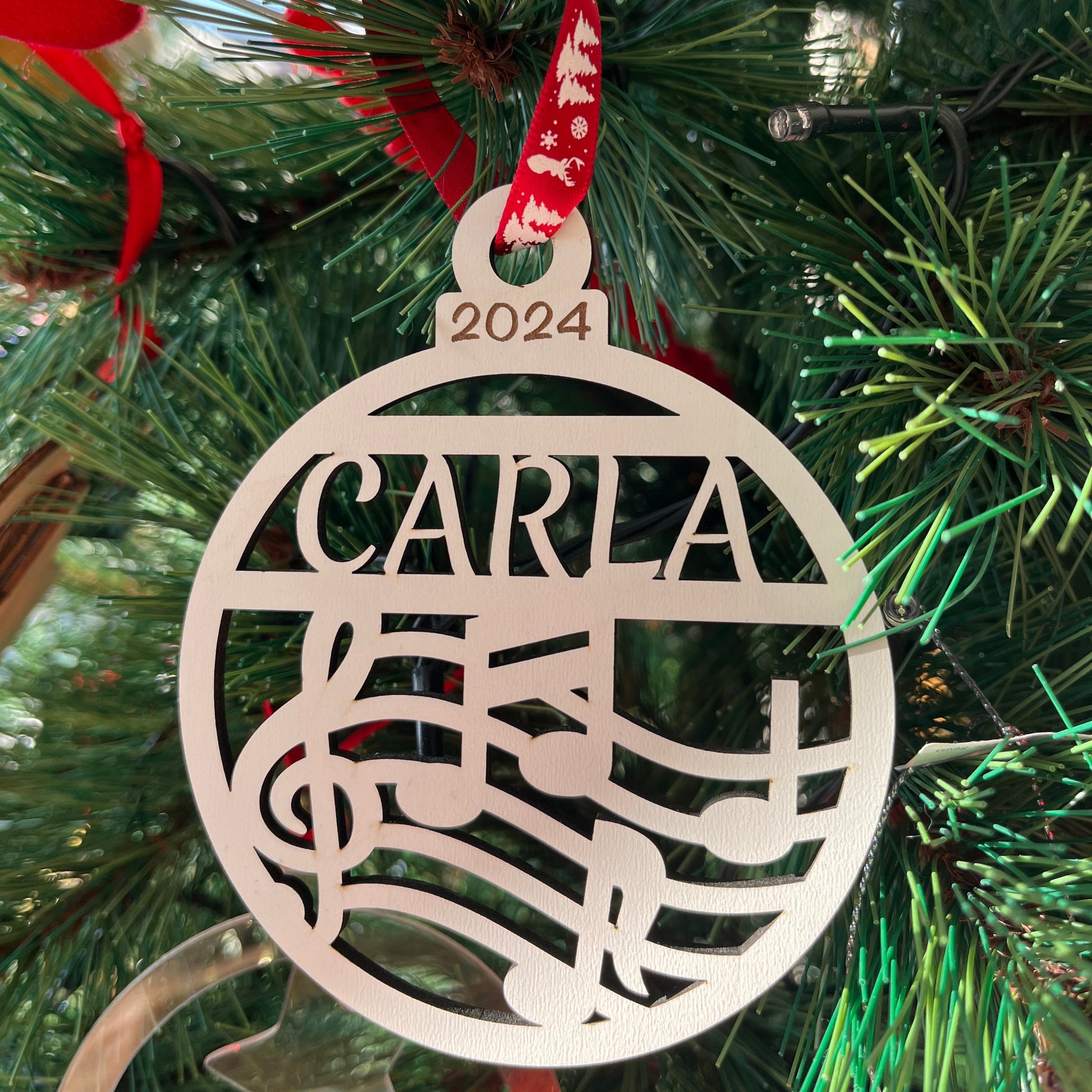 Bola de navidad con diseño de notas musicales en madera capa blanca